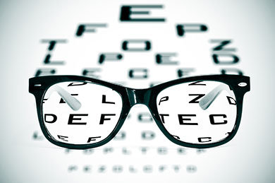 Eyeglasses over a blurry eye chart