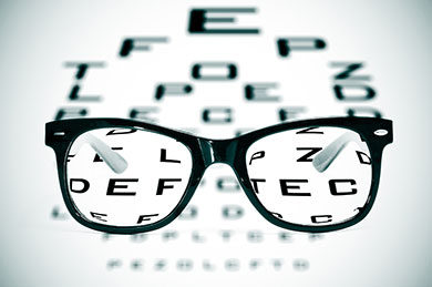 Eyeglasses over a blurry eye chart